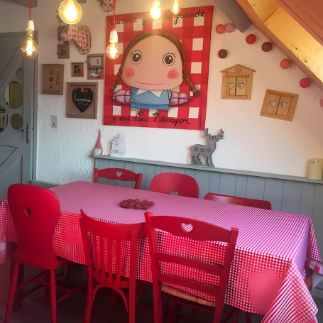 Salle à manger avec des chaises rouges, une table rose et un décor mural ludique.