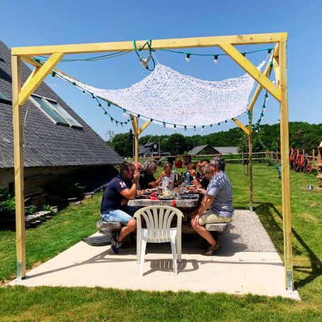 Un groupe de personnes autour d'une grande table sous un abri extérieur.